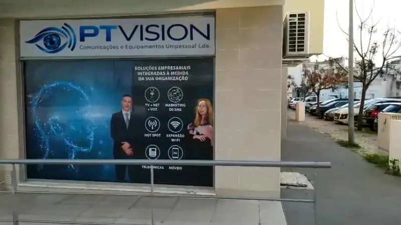 Fachada da PTVISION vista da rua, com o letreiro da empresa